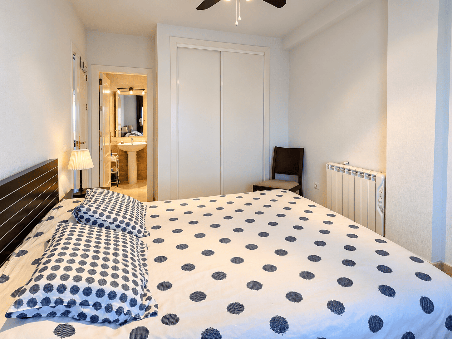 Dormitorio moderno con baño y cama de lunares (1) PRZESTRONNY APARTAMENT Z WIDOKIEM NA MORZE I LAS SOSNOWY W DEHESA DE CAMPOAMOR