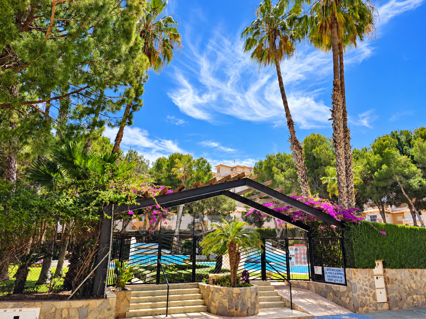 Entrada tropical con piscina y buganvillas PRZESTRONNY APARTAMENT Z WIDOKIEM NA MORZE I LAS SOSNOWY W DEHESA DE CAMPOAMOR
